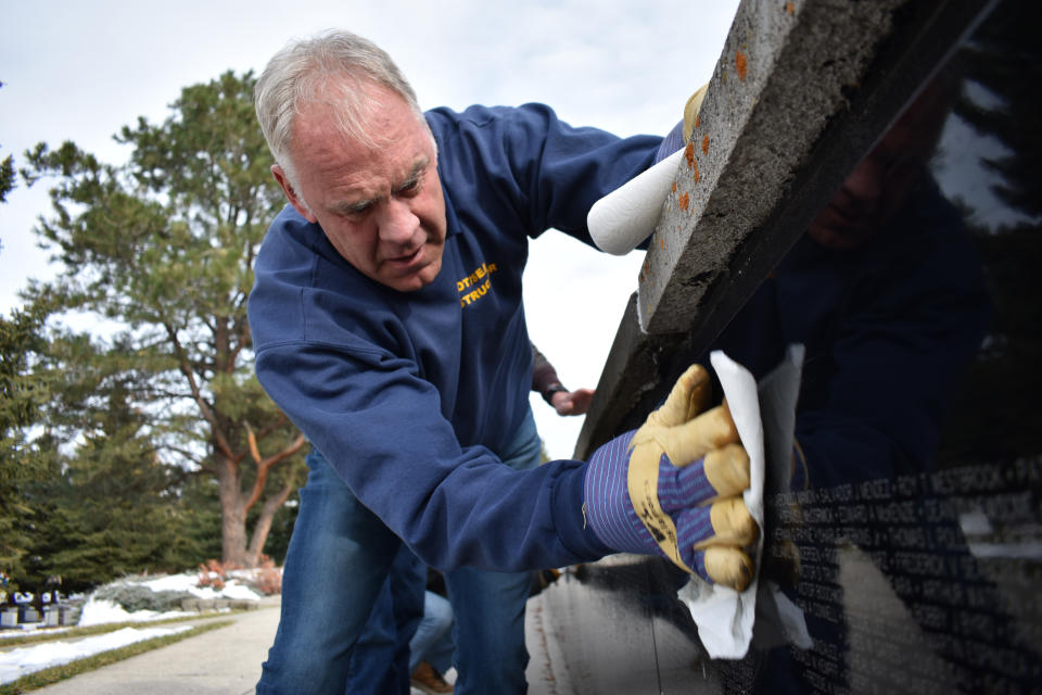 Republican U.S. House candidate Ryan Zinke cleans a panel at the Vietnam War Memorial at Sunset Hills Cemetery, on Oct. 27, 2022, in Bozeman, Mont. The former U.S. Navy SEAL has faced criticism from Democrat Monica Tranel over findings from federal investigators that Zinke lied and misused his job while serving as Trump's Interior Secretary. (AP Photo/Matthew Brown)