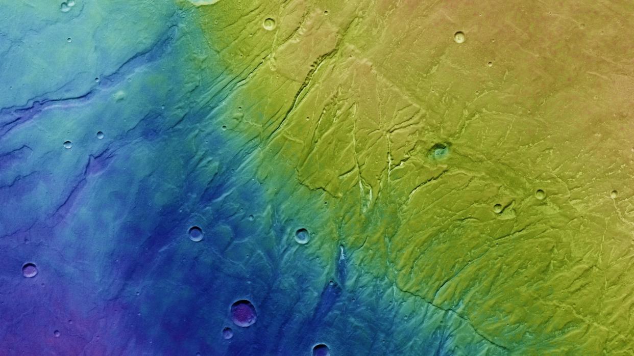  Observations of Mars' Nectaris Fossae and Protva Valles were taken using ESA's Mars Express orbiter on May 23, 2022. This topographic image shows lower parts of the surface in blue and purple, while higher altitude regions are colored white and red.  