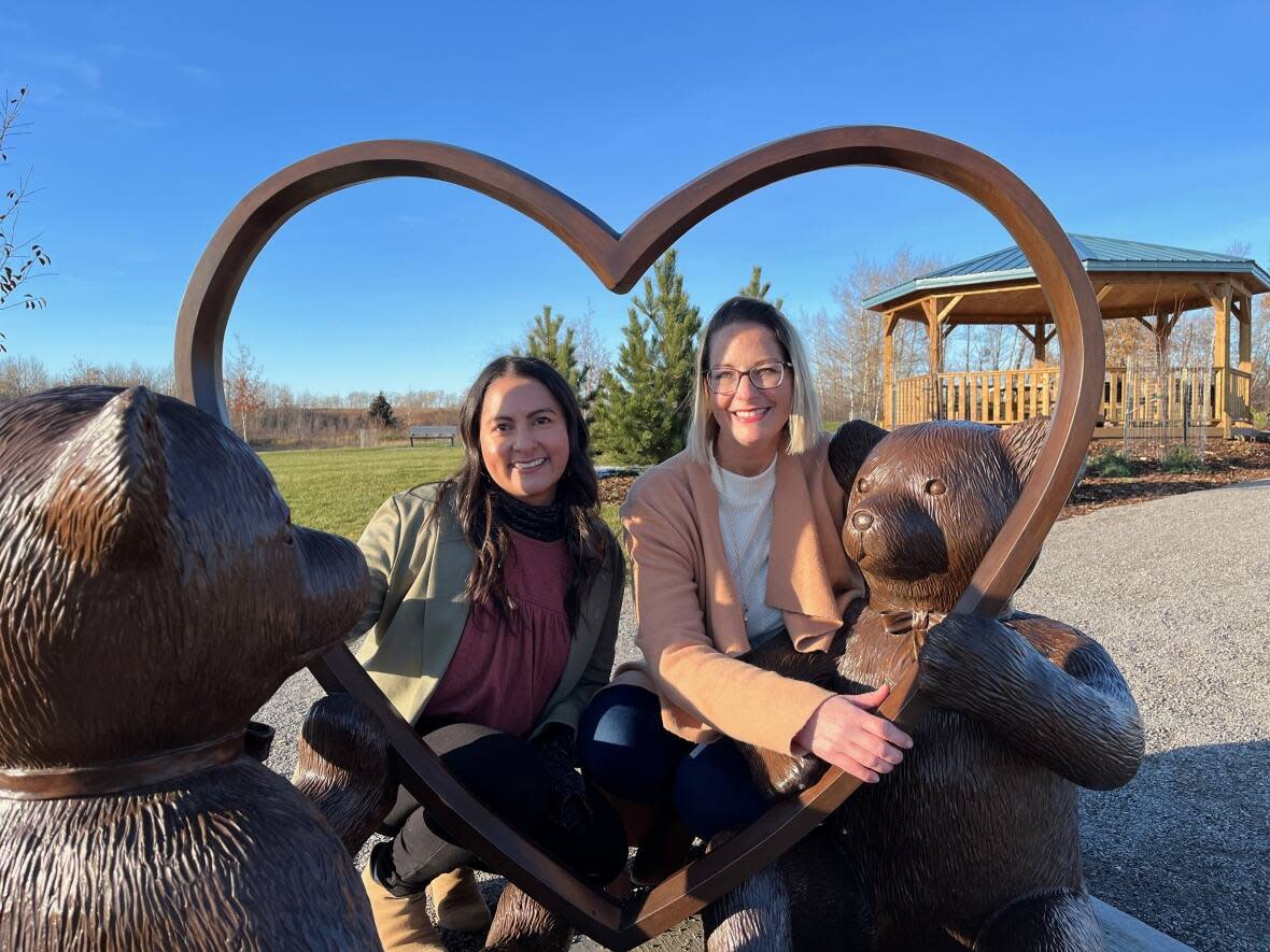 Karen Gilkyson, with Tiny Hands of Hope, left, and Elizabeh Naith, president of Compassionate Friends, partnered to create the Blossoming Garden of Hope in Grande Prairie, Alta. (Luke Ettinger/CBC - image credit)