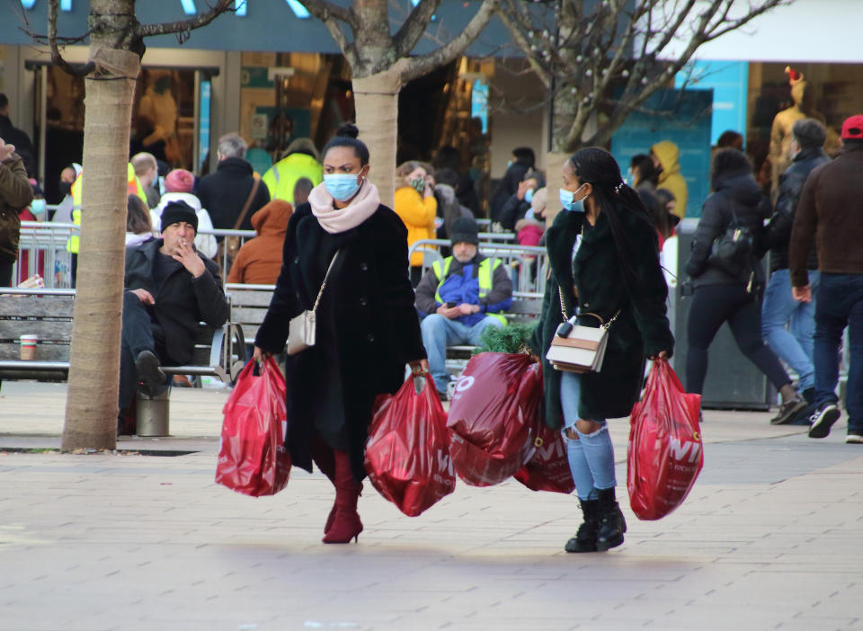  Women wearing face masks carry several shopping bags while walking on the street. On the first weekend of new coronavirus restrictions, the City of Coventry is in the Tier 3 - 'very high risk' with no pubs or restaurants are allowed to trade, except for takeaways, but all shops are open and shoppers out in force. (Photo by Keith Mayhew / SOPA Images/Sipa USA) 