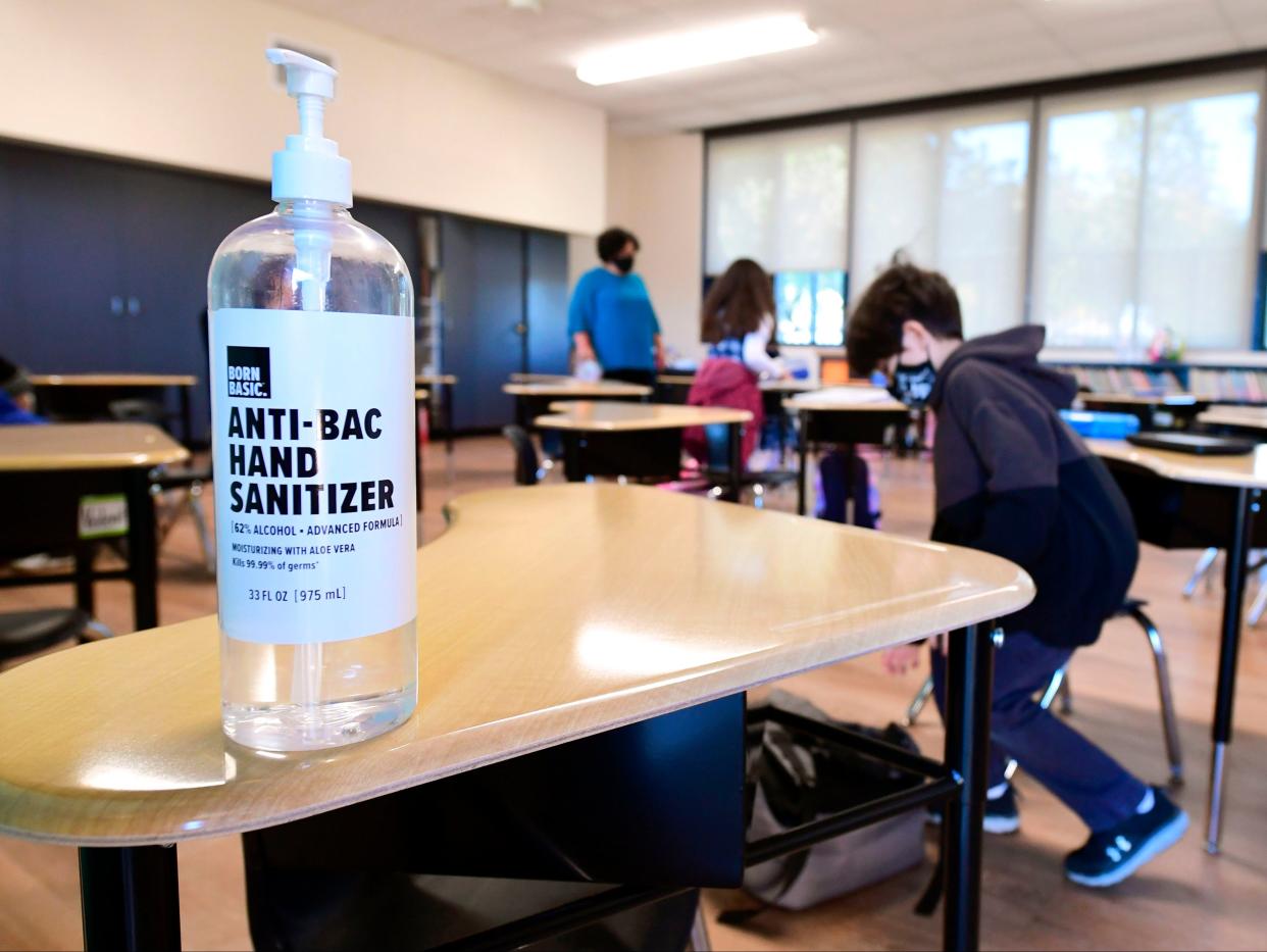 A large container of hand sanitizer sits on a desk for students to use in Second Grade instructor Marisela Sahagun’s classroom at St Joseph Catholic School in La Puente, California on 16 November 2020 (AFP via Getty Images)