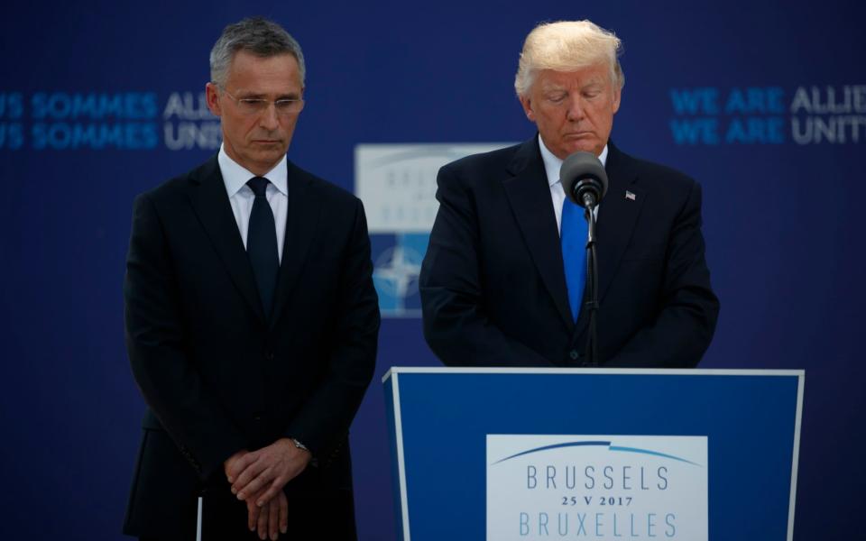 Donald Trump and Nato Secretary General Jens Stoltenberg pause to honour the Manchester victims - Credit: Evan Vucci/AP