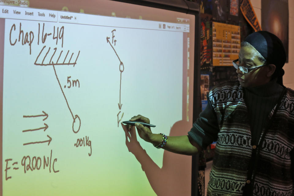 Angela Benjamin teaches the Advanced Placement (AP) Physics class at Woodrow Wilson High School in Washington, Friday, Feb. 7, 2014. The College Board says in a new report that the number of U.S. public students taking Advanced Placement classes doubled over the last decade. The class of 2013 of took 3.2 million AP exams. (AP Photo/Charles Dharapak)