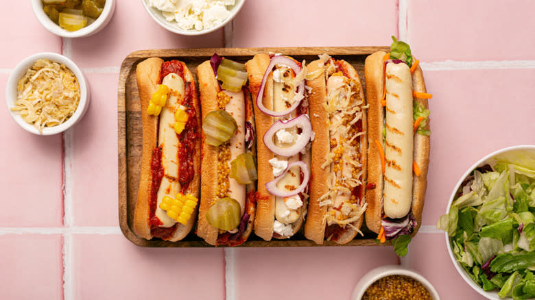 Five hot dogs in a wooden plate
