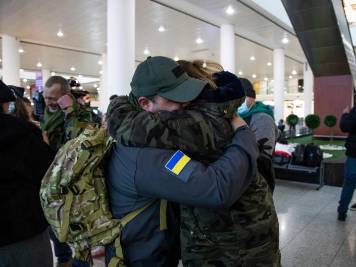 Men hug at airport on way to fight in Ukraine