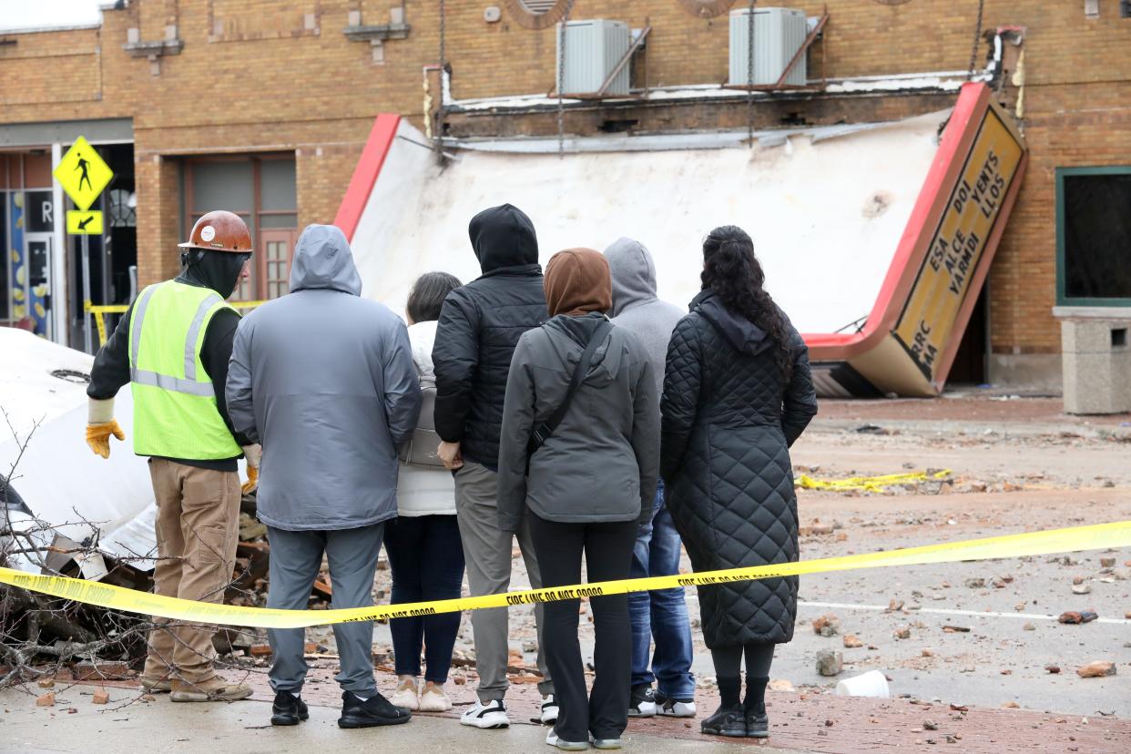 The owner of the Apollo Theatre, Maria Martinez, center in white jacket, visits the theater on Saturday, April 1, 2023, in downtown Belvidere. Twenty-two tornadoes touched down across Illinois and Indiana on Friday, March 31, 2023, including the EF-1 that struck the theater.