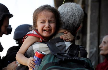 A girl cries as her parents are interviewed by media after displaced civilians are rescued by Iraqi security forces at Old City in western Mosul, Iraq June 23, 2017. REUTERS/Erik De Castro