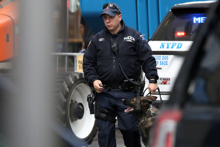 A member of the New York Police Department with a dog is pictured outside the Time Warner Center in the Manahattan borough of New York City after a suspicious package was found inside the CNN Headquarters in New York, U.S., October 24, 2018. REUTERS/Kevin Coombs