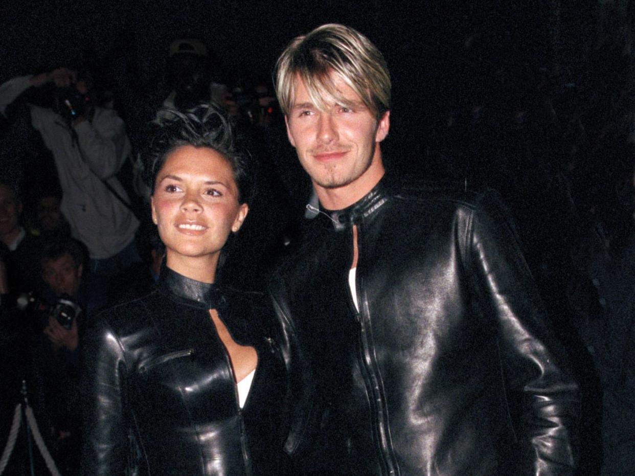 Victoria and David Beckham wearing matching black leather outfits.