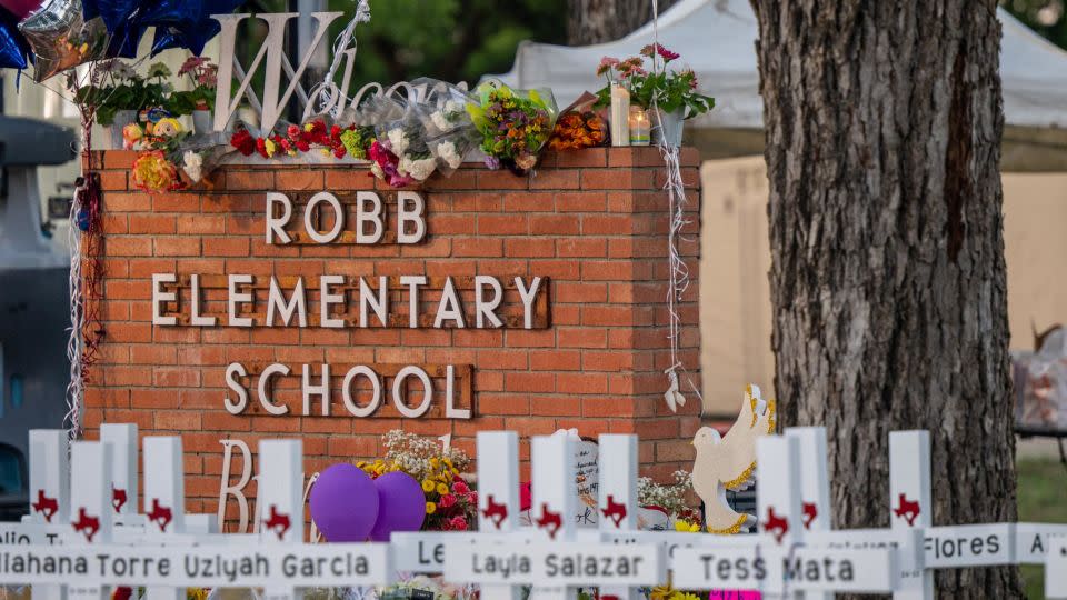 A makeshift memorial surrounds the Robb Elementary School sign following the mass shooting at the Uvalde, Texas, school on May 26. - Brandon Bell/Getty Images