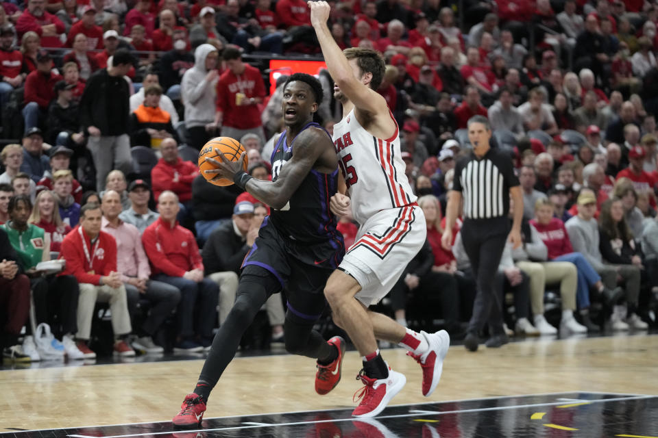 TCU guard Damion Baugh, left, goes to the basket as Utah guard Rollie Worster defends during the first half of an NCAA college basketball game Wednesday, Dec. 21, 2022, in Salt Lake City. (AP Photo/Rick Bowmer)