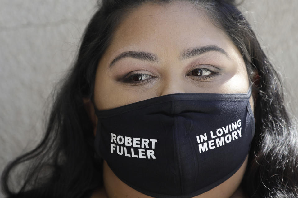 A mourner wears a mask in honor of Robert Fuller during his funeral Tuesday, June 30, 2020, in Littlerock, Calif. Fuller, a 24-year-old Black man was found hanging from a tree in a park in a Southern California high desert city. Authorities initially said the death of Fuller appeared to be a suicide but protests led to further investigation, which continues. (AP Photo/Marcio Jose Sanchez)