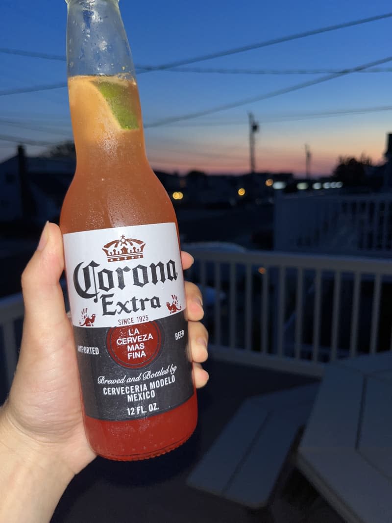 person holding corona sunrise in hand while outside