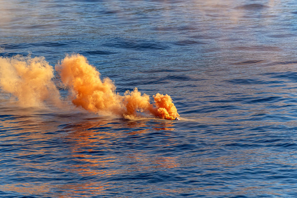 Smoke coming from a signal flare in the water