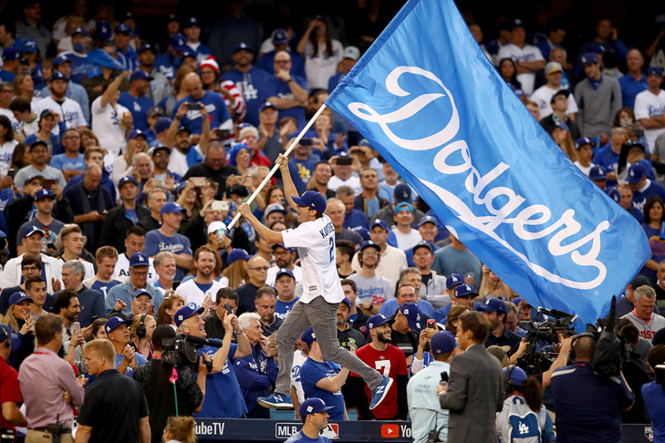 <p>Mila Kunis’s man waved an L.A. Dodgers flag — and riled up the crowd — before Game 6 of the World Series between the Houston Astros and the Dodgers at Dodger Stadium on Tuesday. (Photo: Ezra Shaw/Getty Images) </p>