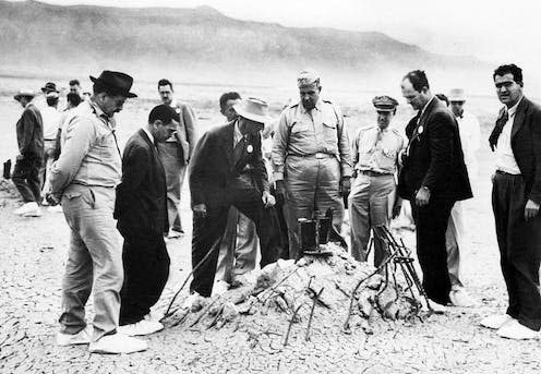 <span class="caption">Robert Oppenheimer (third from left front), Leslie Groves (middle), and other scientists and officers after the Trinity nuclear test in 1945.</span> <span class="attribution"><a class="link " href="https://en.wikipedia.org/wiki/Trinity_(nuclear_test)#/media/File:Trinity_Test_-_Oppenheimer_and_Groves_at_Ground_Zero_001.jpg" rel="nofollow noopener" target="_blank" data-ylk="slk:US Army Signal Corps;elm:context_link;itc:0;sec:content-canvas">US Army Signal Corps</a></span>