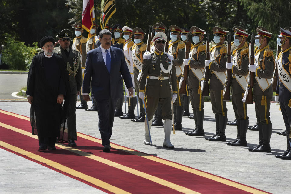 Venezuela's President Nicolas Maduro, third left, reviews an honor guard as he is accompanied by his Iranian counterpart Ebrahim Raisi, left, during his official welcoming ceremony at the Saadabad Palace in Tehran, Iran, Saturday, June 11, 2022. (AP Photo/Vahid Salemi)