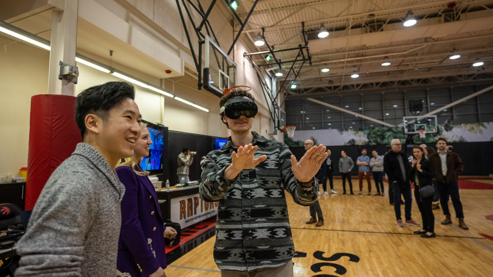 Un journaliste du terrain d'entraînement de la Scotiabank Arena essaie une fonctionnalité de réalité virtuelle dans le cadre de l'Immersive Basketball Experience, lancée par MLSE et l'initiative SpaceX d'AWS.  Il permet au spectateur de voir des rendus 3D grandeur nature de jeux de sport.  (Crédit : MLSE)