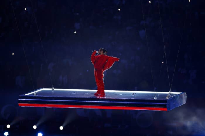 Rihanna singing as she stands on a floating platform