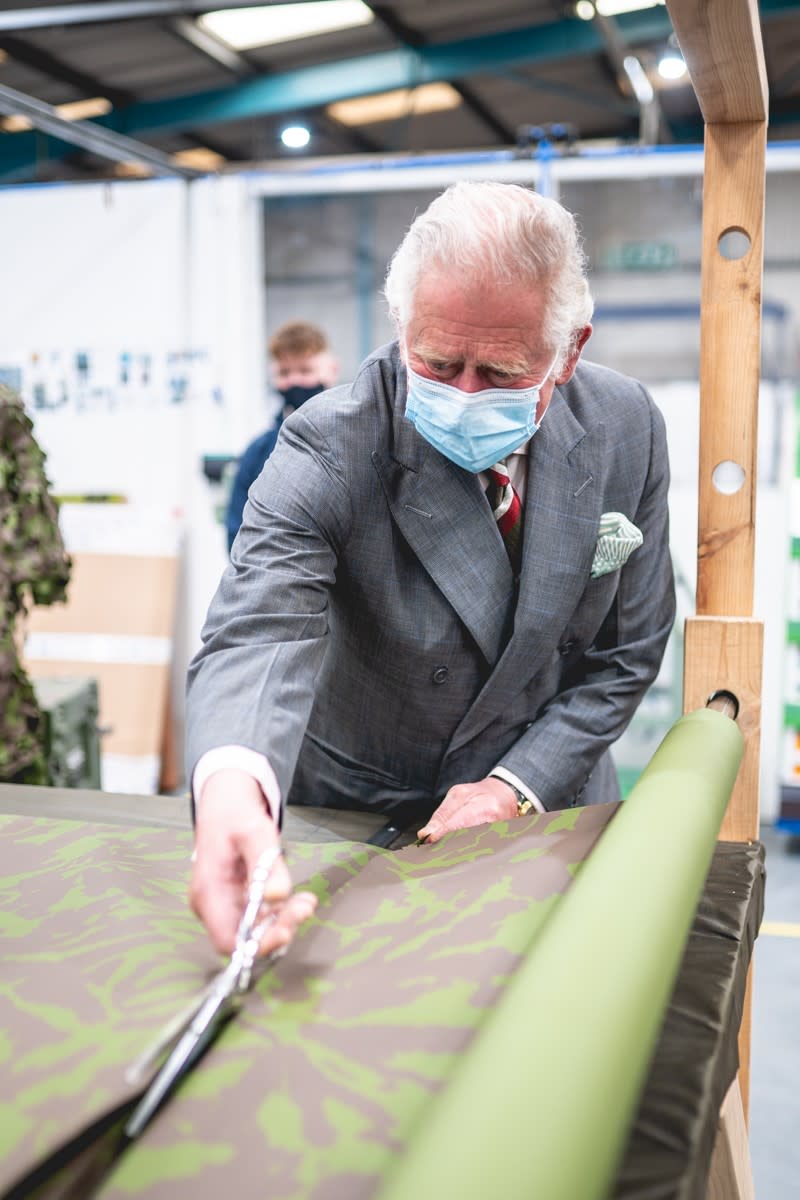 Charles cuts camouflage netting during his visit