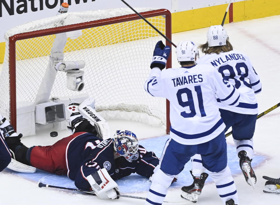 Toronto Maple Leafs right wing William Nylander (88) scores past Columbus Blue Jackets goaltender Joonas Korpisalo (70) as Leafs center John Tavares (91) watches during the second period of an NHL hockey playoff game Thursday, Aug. 6, 2020, in Toronto. (Nathan Denette/The Canadian Press via AP)