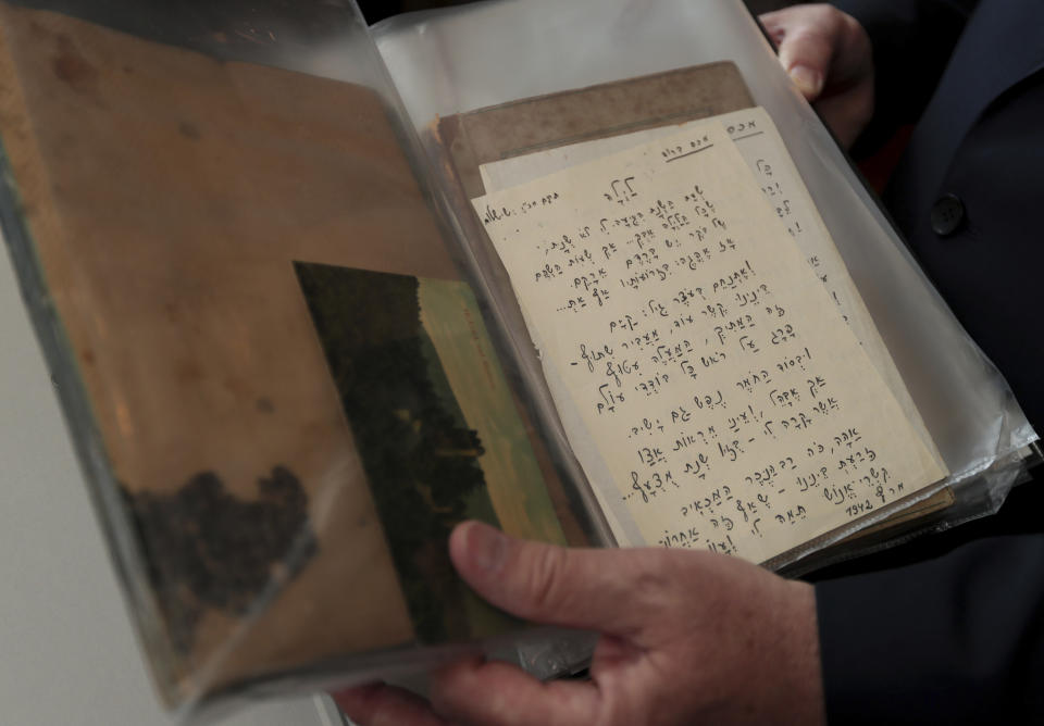 Israel's ambassador in Germany, Jeremy Issacharoff, holds documents prior to a handing over ceremony at the embassy of Israel in Berlin, Germany, Tuesday, May 21, 2019. German authorities are handing over to Israel some 5,000 documents kept by a confidant of Franz Kafka, a trove whose plight could have been plucked from one of the author's surreal stories. (AP Photo/Michael Sohn)