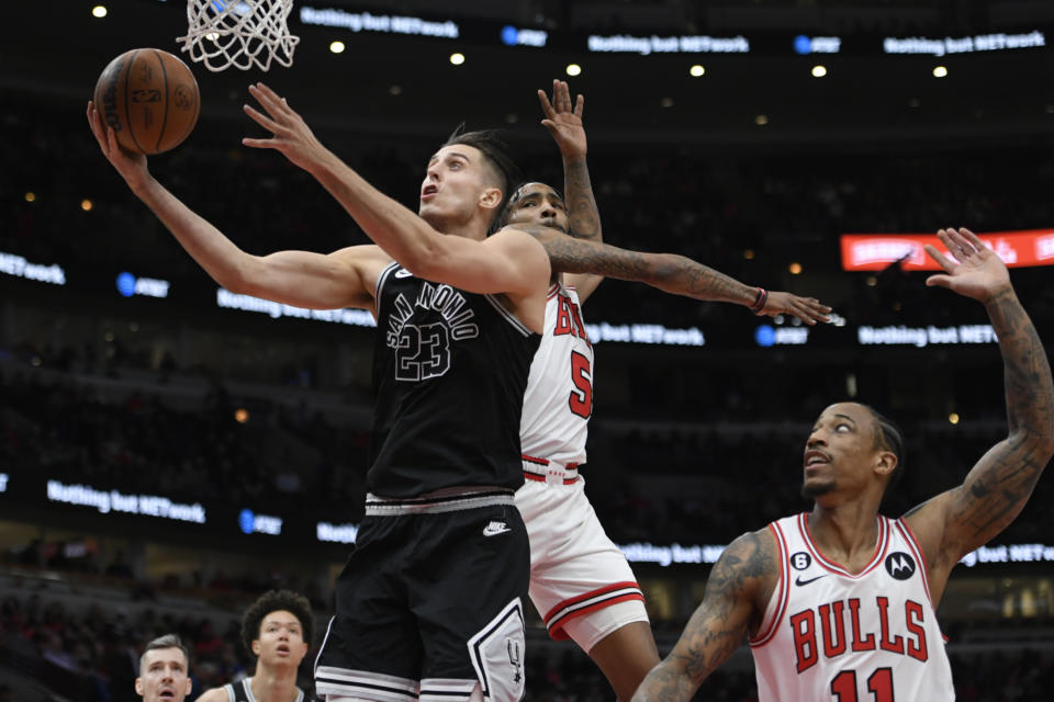 San Antonio Spurs' Zach Collins (23) goes up to shoot against Chicago Bulls' Derrick Jones Jr. (5) and DeMar DeRozan (11) during the first half of an NBA basketball game Monday, Feb. 6, 2023, in Chicago. (AP Photo/Paul Beaty)
