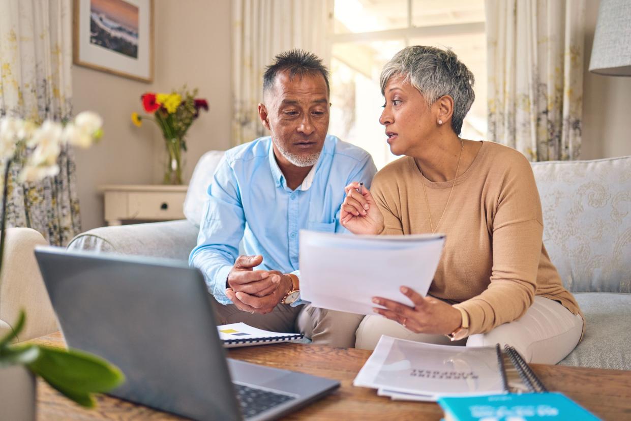 Laptop, documents and accounting with a senior couple in the home living room for retirement or finance planning. Computer, budget or investment savings with a mature man and woman in a house