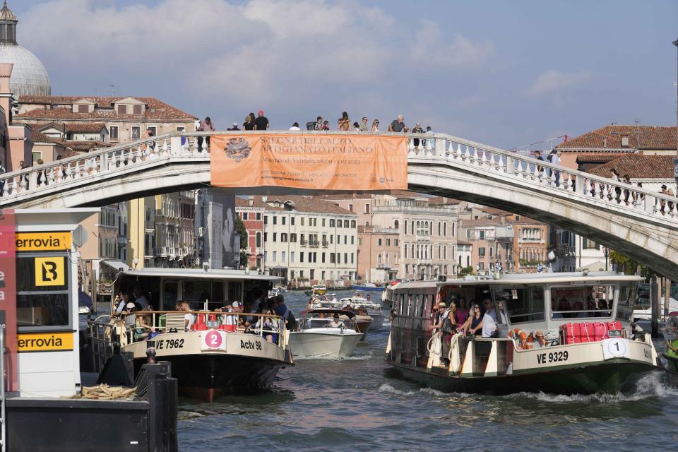 A view of several boats on a canal, in Venice, Italy, Wednesday, Sept. 13, 2023. The Italian city of Venice has been struggling to manage an onslaught of tourists in the budget travel era. The stakes for the fragile lagoon city are high this week as a UNESCO committee decides whether to insert Venice on its list of endangered sites. (AP Photo/Luca Bruno)