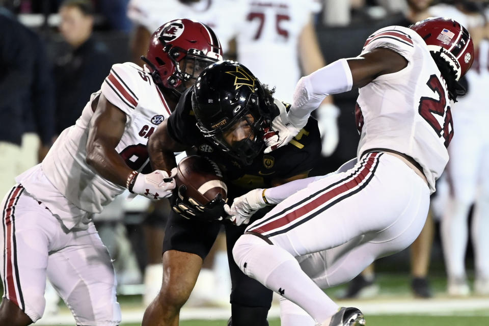 Vanderbilt wide receiver Will Sheppard, center, is tackled by South Carolina's Payton Mangrum, left, and Darius Rush (28) on a punt return in the first half of an NCAA college football game Saturday, Nov. 5, 2022, in Nashville, Tenn. (AP Photo/Mark Zaleski)