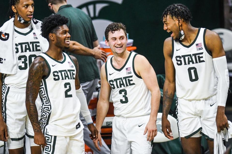 For left, Michigan State's Rocket Watts, Foster Loyer and Aaron Henry joke around on the bench late during the second half of the game against  Eastern Michigan on Wednesday, Nov. 25, 2020, at the Breslin Center in East Lansing.