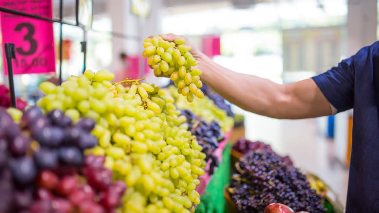 Man holding bunch of grapes