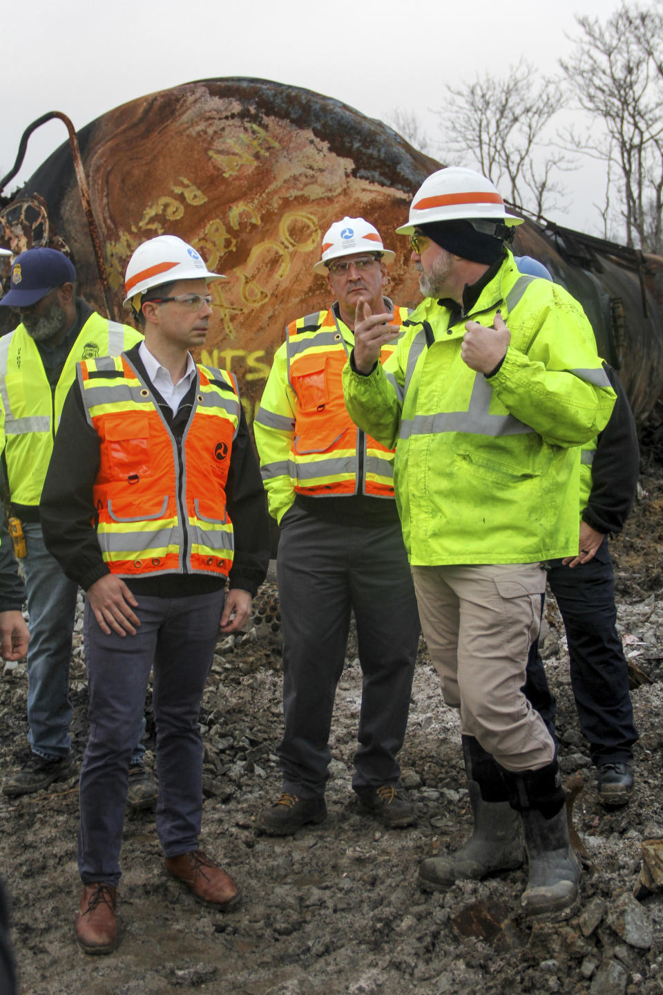 Transportation Secretary Pete Buttigieg, left, talks with Randy Keltz, manager of tank car safety programs with the Federal Railroad Administration, right, as another staff member looks on, Thursday, Feb. 23, 2023, in East Palestine, Ohio, during a tour of the site of a Norfolk Southern train derailment. (Allie Vugrincic/The Vindicator via AP, Pool)