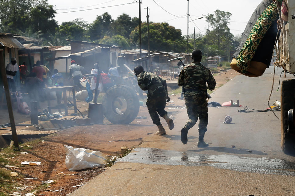 Central African Republic policemen chase looters attacking a broken-down truck as thousands of Muslim residents from Bangui and Mbaiki flee Bangui in a mass exodus using cars, pickups, trucks, lorries and motorcycles, escorted by Chadian troops Friday Feb. 7, 2014. Tit-for-tat violence killed more than 1,000 people in Bangui alone in a matter of days in December. An untold number have died in the weeks that followed, with most of the attacks in Bangui targeting Muslims. (AP Photo/Jerome Delay)