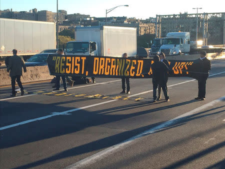 Protesters holding a pro-immigrant sign blocked lanes on the George Washington Bridge halting traffic during the morning rush hour between New Jersey and New York City, U.S., October 26, 2016. Courtesy Tidal Magazine / #decolonizethisplace/Handout via REUTERS