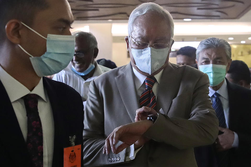Former Malaysian Prime Minister Najib Razak, center, arrives at the Kuala Lumpur High Court complex in Kuala Lumpur, Malaysia, Tuesday, July 28, 2020. Najib was convicted Tuesday of crimes involving the multibillion-dollar looting of a Malaysian state investment fund that brought down his government in a shocking election ouster two years ago.(Fazry Ismail/Pool Photo via AP)