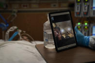 Sonya Rodriguez wipes her tears after seeing her father via video chat arranged by chaplain Kevin Deegan in a COVID-19 unit at Providence Holy Cross Medical Center in the Mission Hills section of Los Angeles on Saturday, Jan. 9, 2021. (AP Photo/Jae C. Hong)