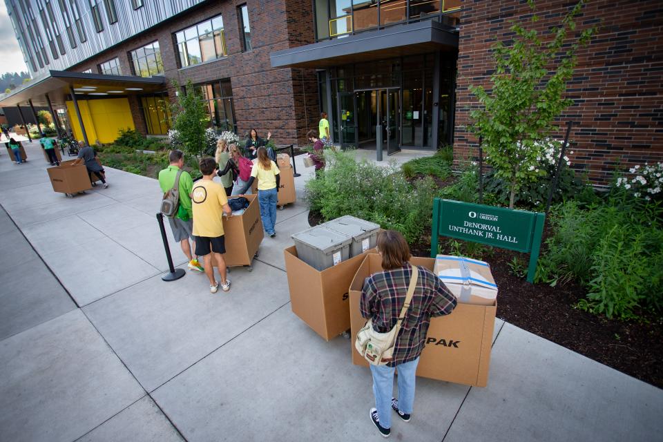 Students and their families line up before entering DeNorval Unthank Jr. Hall during move-in day at the University of Oregon Thursday in Eugene. The move-in process, split into two days this year, was efficient and caused little impact to area traffic.