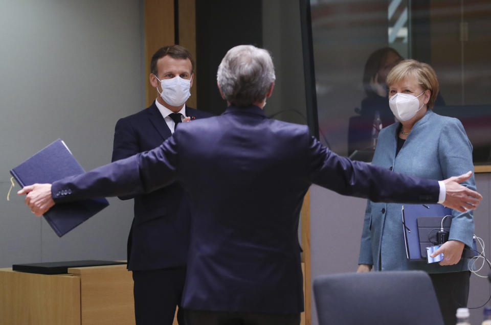 European Parliament President David Sassoli, center, speaks with French President Emmanuel Macron, left, and German Chancellor Angela Merkel during a round table meeting at an EU summit at the European Council building in Brussels, Thursday, Oct. 15, 2020. European Union leaders are meeting in person for a two-day summit amid the worsening coronavirus pandemic to discuss topics ranging from Brexit to climate and relations with Africa. (Yves Herman, Pool via AP)