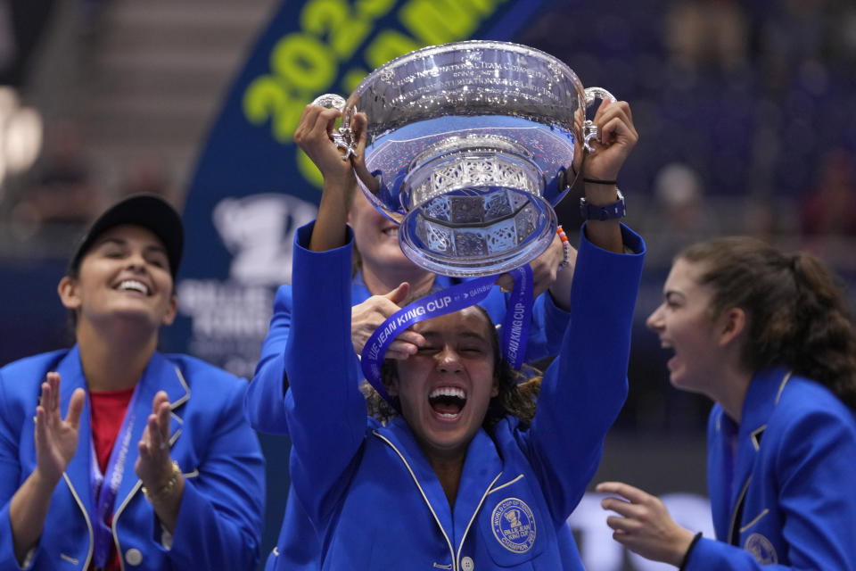 Canada's Leylah Fernandez lifts the trophy as she celebrates with members of her team after wining the final singles tennis match against Italy's Jasmine Paolini, during the Billie Jean King Cup finals in La Cartuja stadium in Seville, southern Spain, Spain, Sunday, Nov. 12, 2023. (AP Photo/Manu Fernandez)