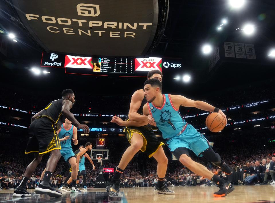 Nov 16, 2022; Phoenix, AZ, USA; Phoenix Suns guard Devin Booker (1) drives past Golden State Warriors guard 	Klay Thompson (11) at Footprint Center.