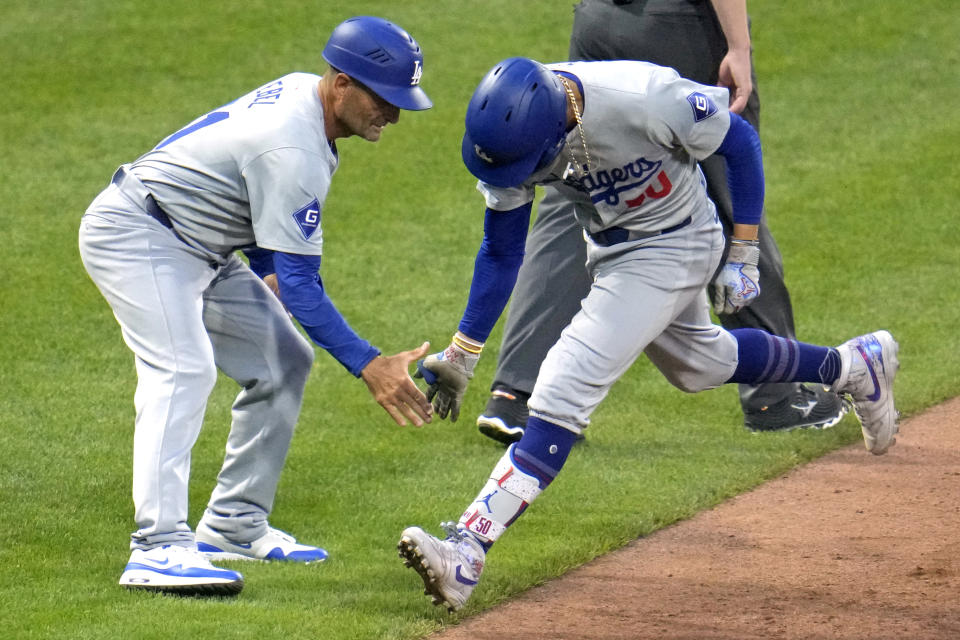 Los Angeles Dodgers' Mookie Betts, right, is greeted by third base coach Dino Ebel on the way to scoring on a three-run home run against the Pittsburgh Pirates during the fifth inning of a baseball game in Pittsburgh, Thursday, June 6, 2024. (AP Photo/Gene J. Puskar)