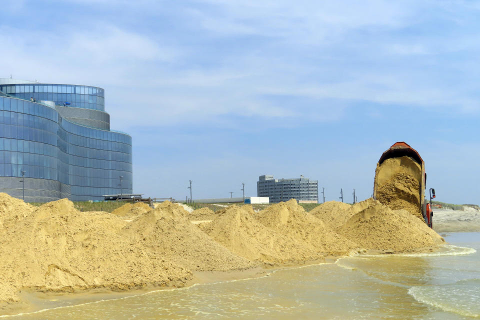 FILE - A load of sand is dumped on the beach in front of the Ocean Casino Resort in Atlantic City, N.J., Friday, May 12, 2023. The Ocean, Resorts and Hard Rock casinos want federal officials to expedite a beach replenishment project planned for 2024 so that it creates usable beaches this summer, but the U.S. Army Corps of Engineers says work might not start until the fall. (AP Photo/Wayne Parry, File)