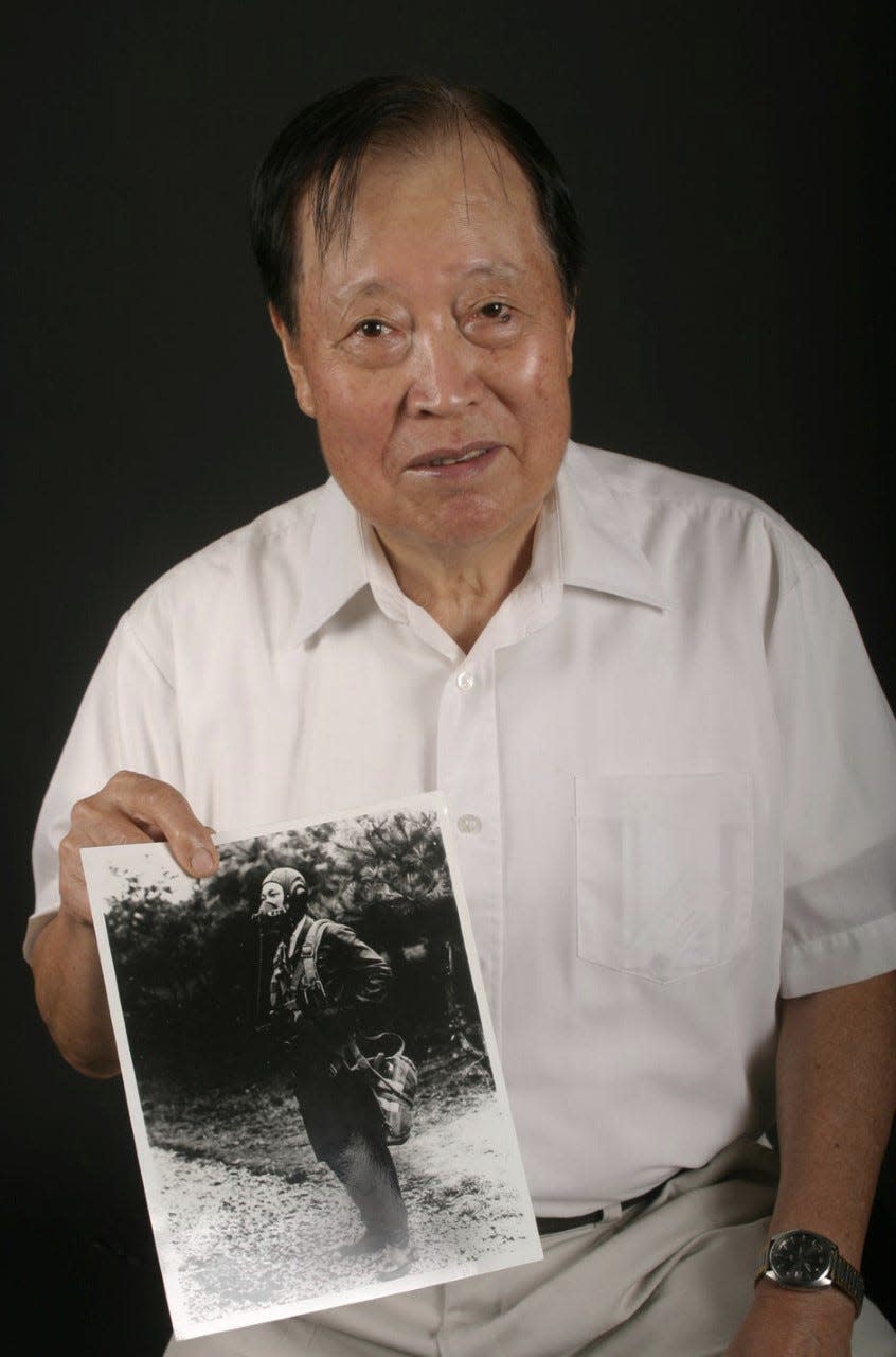 Retired Embry-Riddle Aeronautical University Professor Kenneth Rowe, seen here in 2013, holds a photo of himself when he was a fighter pilot for the North Korean Air Force during the Korean War. Rowe, at age 21, escaped from North Korea in 1953 by flying his MiG-15 fighter jet to a U.S. air base in South Korea. He died at his Daytona Beach home on Dec. 26, 2022, just a couple weeks shy of his 91st birthday.