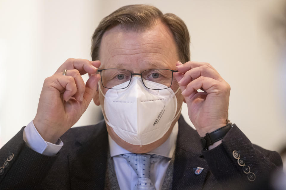 Thuringia's state governor Bodo Ramelow holds his glasses during a break as part of a special plenary session of the Thuringian parliament in Erfurt, Germany, Wednesday, Jan. 20, 2021. State governor Ramelow has apologized for referring to her as “little Merkel” during a recent online event, saying he had unintentionally displayed macho behavior. (Michael Reichel/dpa via AP)