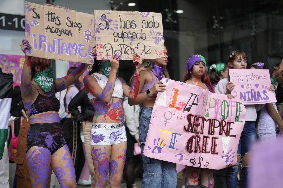 Mujeres pintadas con manos moradas en apoyo a las víctimas de violencia de género, en el Día Internacional de la Mujer, en Bogotá, Colombia, el viernes 8 de marzo de 2024. (AP Foto/Fernando Vergara)