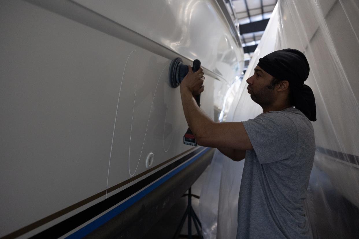 Raymond Strubble polishes up the hall of a boat at Yacht Basin on May 3, 2024.