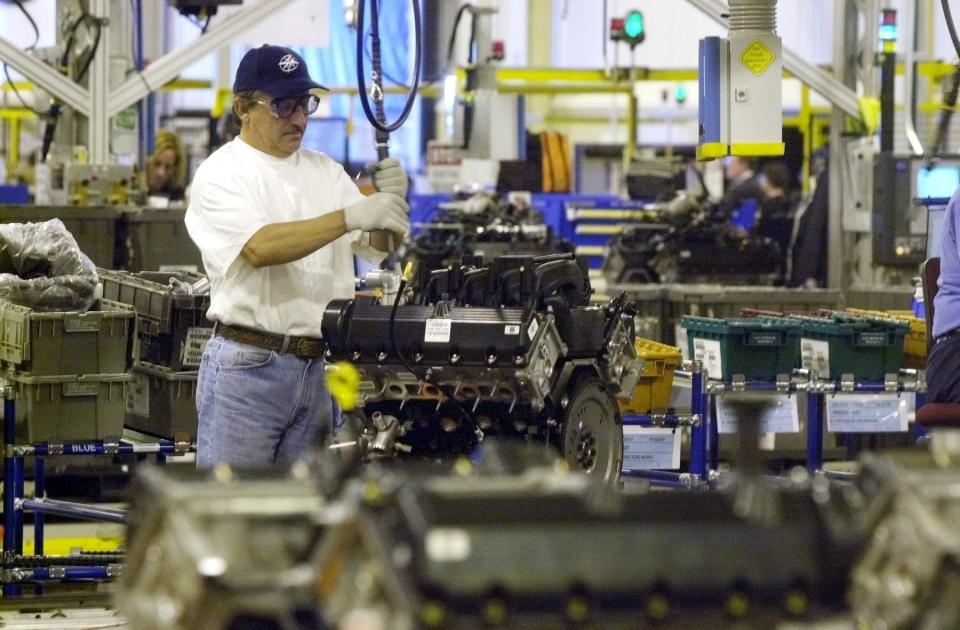 An engine worker assembles part of a Ford V-8 engine on the assembly line at the Essex Engine Plant in Windsor, Ontario, Tuesday, April 29, 2003. Ford Motor Co., which turns 100 on June 16, reached a milestone Tuesday when the automaker produced its 100 millionth V-8 engine. The new 5.4-liter, 3-valve Triton V-8 rolled off the line in Windsor, 70 years after Ford's first mass-produced V-8 was built.  (AP Photo/Carlos Osorio)