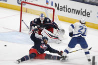 Columbus Blue Jackets' Seth Jones, front left, knocks the puck away from Tampa Bay Lightning's Brayden Point, as Blue Jackets' Joonas Korpisalo, of Finland, protects the net during the first period of an NHL hockey game Thursday, Jan. 21, 2021, in Columbus, Ohio. (AP Photo/Jay LaPrete)