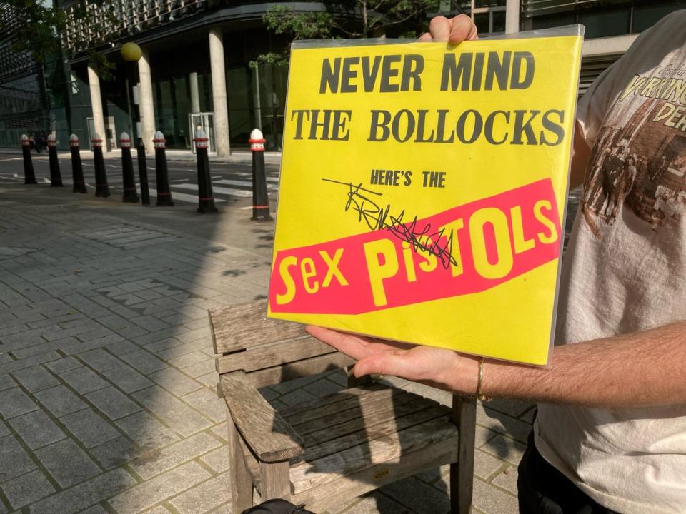 A member of the public holds a copy of the Sex Pistols’ Never Mind The Bollocks, signed by John Lydon, outside acourt (Sam Tobin/PA) (PA Wire)